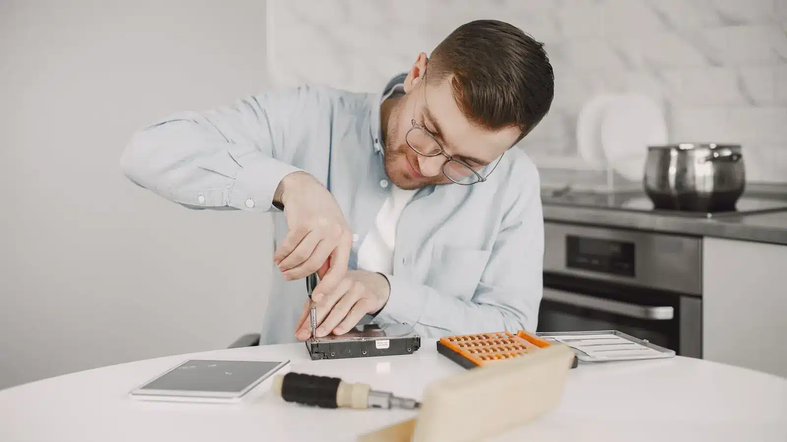 Vrijwilliger repareert een apparaat in een repair café, een voorbeeld van circulaire economie