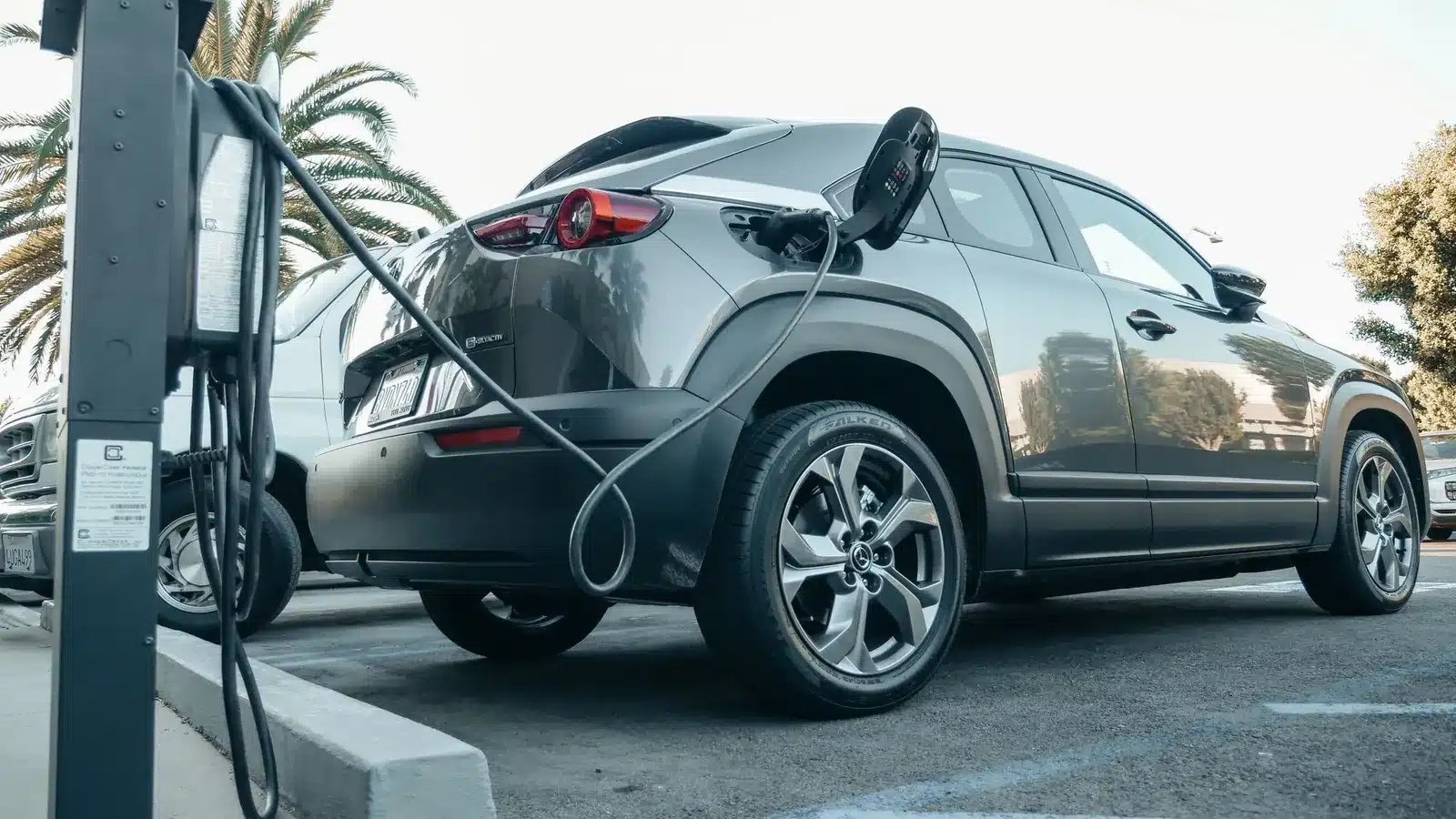 Elektrische auto aan de laadpaal op een oprit, handig om te weten als je een elektrische auto wilt kopen