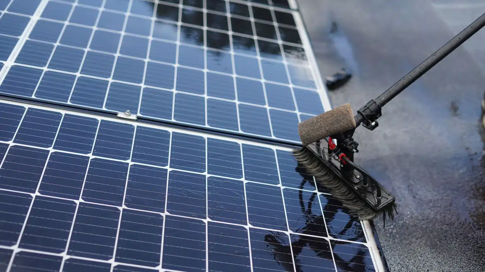 Zonnepanelen schoonmaken met een zachte borstel aan een telescoopsteel